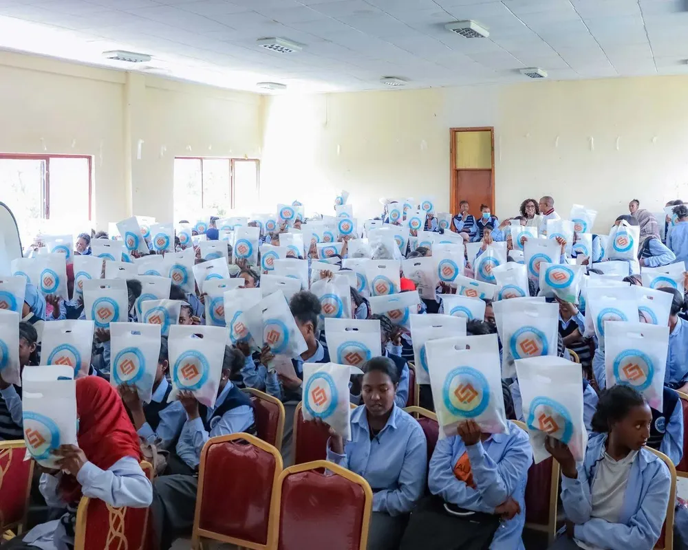A hall full of schoolgirls receiving dignity kits