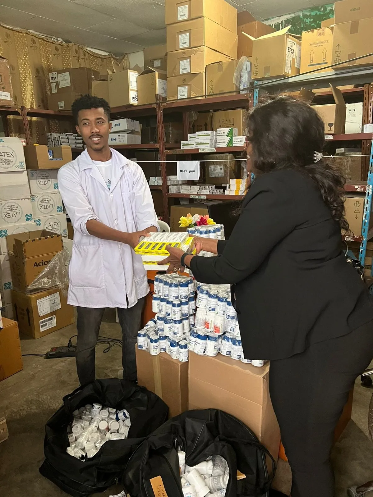 Dr. Yetmwork hands medical supplies to Mekedonia staff